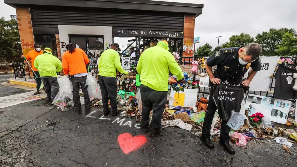 애틀랜타시 경찰과 청소요원들이 6일 오전 불탄 웬디스 주변의 시위대가 사용하던 물품들을 제거하고 있다.