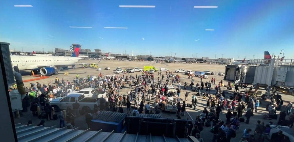 총기 오발 사고가 난 뒤 여객기에서 내려 공항 활주로 옆 타맥에 내려선 승객들[공항 이용자의 트위터 계정 사진 캡처. 재판매 및 DB 금지]