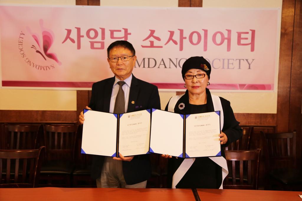 이홍기 애틀랜타한인회장과 장세희 사임당 소사이어티 회장이 28일 양해각서에 서명하고 교환하고 있다.