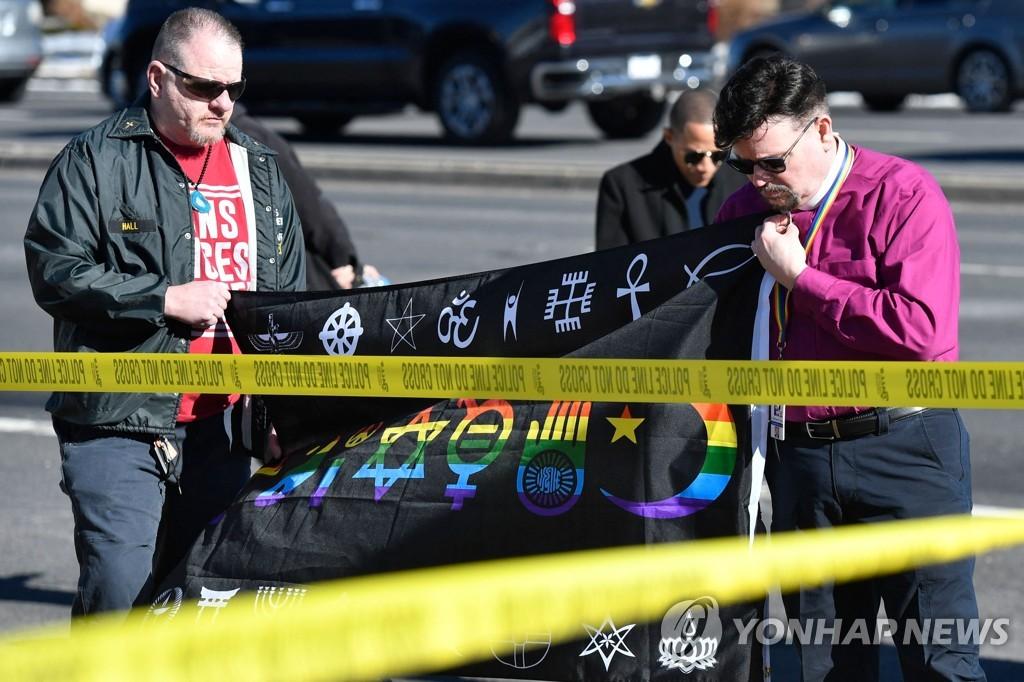 20일 30여명의 사상자를 낸 미국 콜로라도주 성소수자 클럽 총격 사건 현장 앞에서 희생자를 추모하는 상징물을 설치하는 주민들.