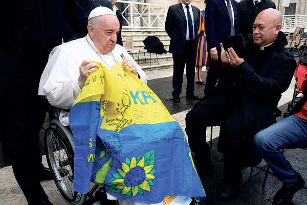  프란치스코 교황이 지난 16일 일반 알현 행사에서 우크라이나 국기를 들도 신자들을 만나고 있다. [로이터]