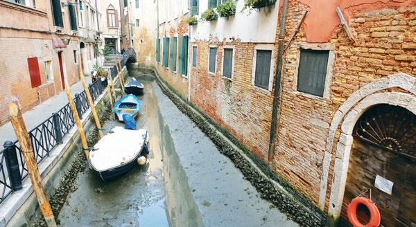  극심한 가뭄으로 운하가 바닥을 드러내며 평소 같으면 전 세계 관광객들을 실어나르던 베네치아의 명물인 곤돌라들이 영업을 중단한 채 세워져 있다. [로이터]