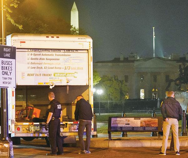  지난 22일 밤 백악관 인근 보안장벽을 들이받은 유홀 차량을 경찰이 조사하고 있다. [로이터]
