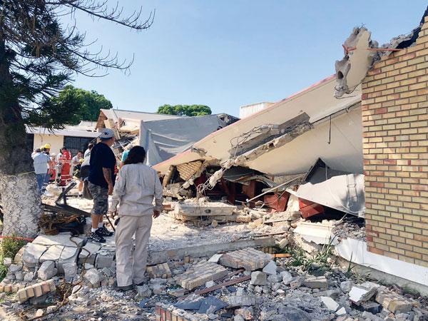  무너진 성당 건물에서 구조대가 수색 작업을 벌이고 있다. [로이터]