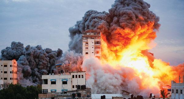  7일 새벽 팔레스타인 무장단체 하마스의 기습공격에 대한 보복으로 이스라엘이 공습에 나서면서 폭격을 당한 팔레스타인 가자지구의 한 건물에서 거대한 화염과 검은 연기가 치솟고 있다. [로이터]