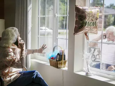 코로나19로 창문 너머 전화로 노래불러주는 80대 노모