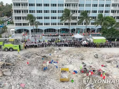 아파트 붕괴 현장서 희생자 추모하는 수색대