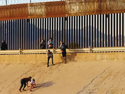 미·멕시코 국경 장벽 넘는 난민 신청 이민자들