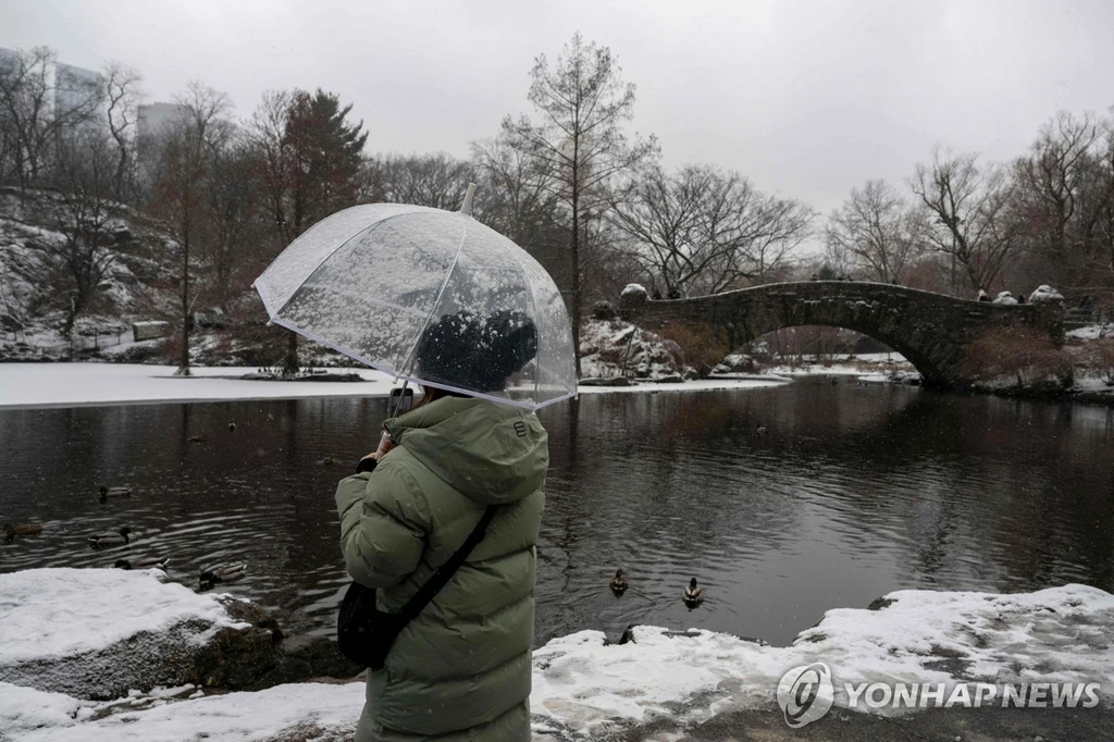 뉴욕에서 우산을 쓰고 있는 시민[AFP=연합뉴스. 재판매 및 DB 금지]