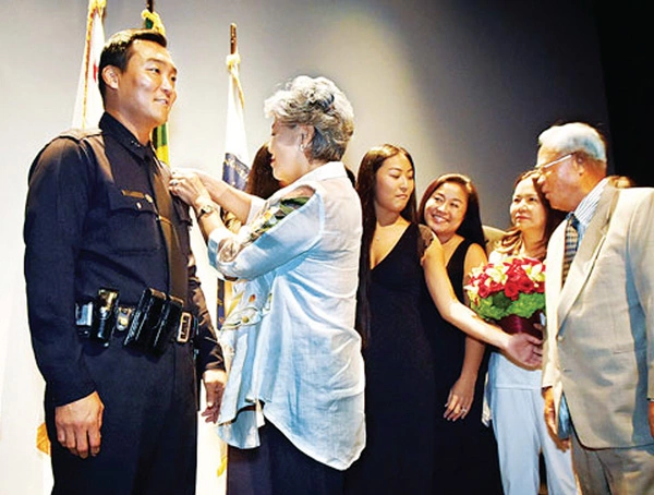 도미니크 최 LAPD 임시국장이 지난 2019년 한인 최초로 부국장 진급 기념식에서 모친 최진려씨와 가족들로부터 축하를 받는 모습. [박상혁 기자]