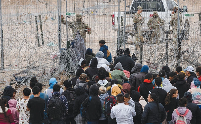  이민자 100여 명이 지난 21일 텍사스 남부 엘패소 국경 철조망을 뚫고 월경을 시도하고 있다. [로이터=사진제공]
