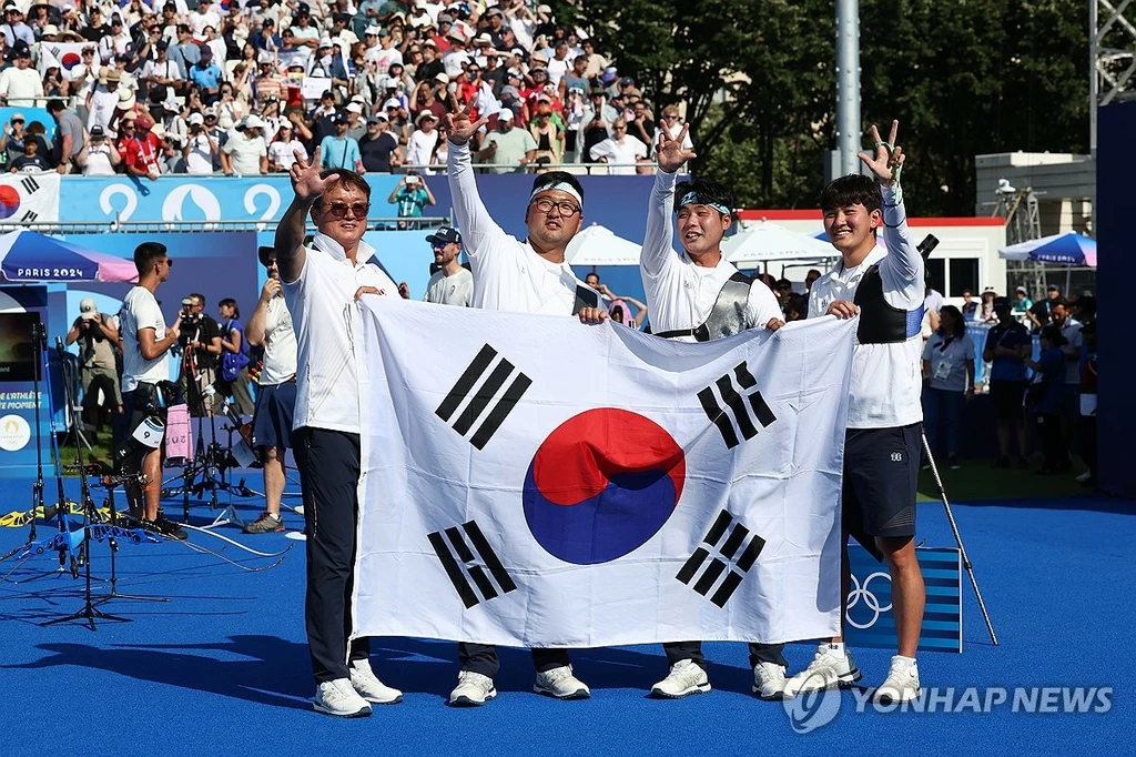  29일(현지시간) 프랑스 파리 레쟁발리드 양궁 경기장에서 열린 2024 파리올림픽 양궁 남자 단체 결승전 한국과 프랑스의 경기.금메달을 차지한 한국 대표팀 선수들이 태극기를 들고 세리머니를 하고 있다.(파리=연합뉴스) 