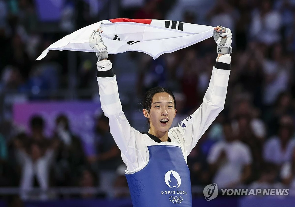 8일(현지시간) 프랑스 파리 그랑팔레 태권도경기장에서 열린 2024 파리올림픽 태권도 여자 57kg급 결승에서 한국의 김유진이 이란의 나히드 키야니찬데를 꺾고 금메달을 확정한 뒤 태극기를 들고 환호하고 있다. (파리=연합뉴스)