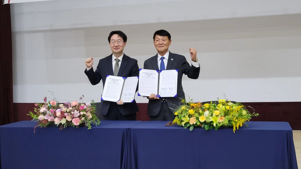 이경철 총회장(오른쪽)과 정희권 이사장이 업무협약 체결 후 손을 들어 '파이팅'을 외치고 있다.