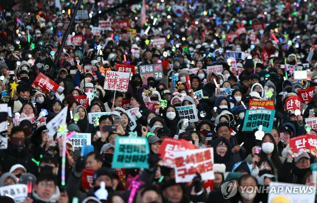 윤석열 대통령 탄핵소추안이 가결된 14일 서울 여의도 국회 앞에서 열린 집회에 참석한 시민들이 환호하고 있다./연합