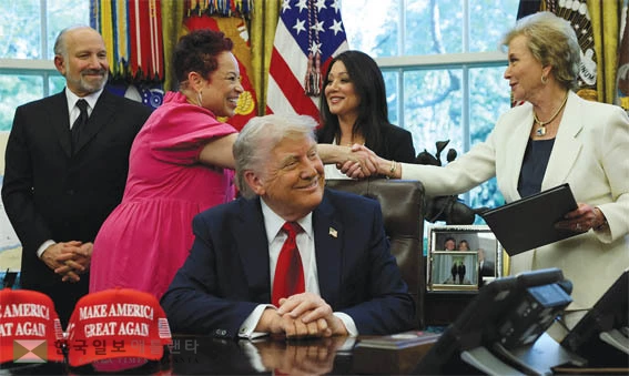 린다 맥마흔 연방 교육부 장관(맨 오른쪽)이 지난달 23일 백악관에서 열린 대통령 행정 명령 서명식에서 노스캐롤라이나주 교육 활동가 아넷 올브라이트와 악수하고 있다. <로이터>