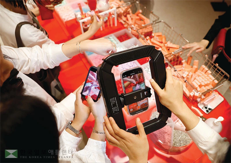  K-뷰티 소비자들이 한국산 화장품 매대에 몰려 상품을 촬영하는 모습. [로이터]