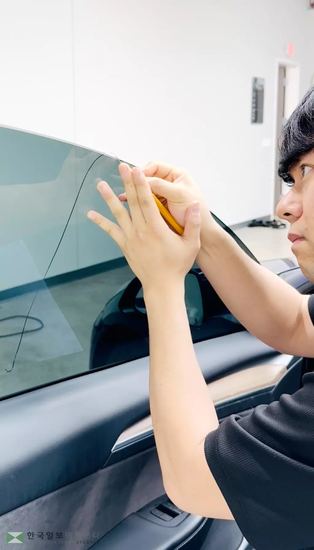 임은환 대표가 차량에 틴팅 필름을 정교하게 시공하는 모습.