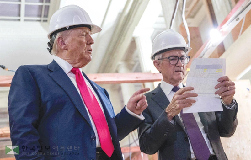  도널드 트럼프(왼쪽) 대통령이 24일 워싱턴 DC 내 연방준비제도(FRB·연준) 리모델링 현장을 방문해 리모델링 비용이 연준이 발표한 것보다 많이 들어갔다는 내용의 서류를 제롬 파월 연준 의장에게 건네고 있다. [로이터]