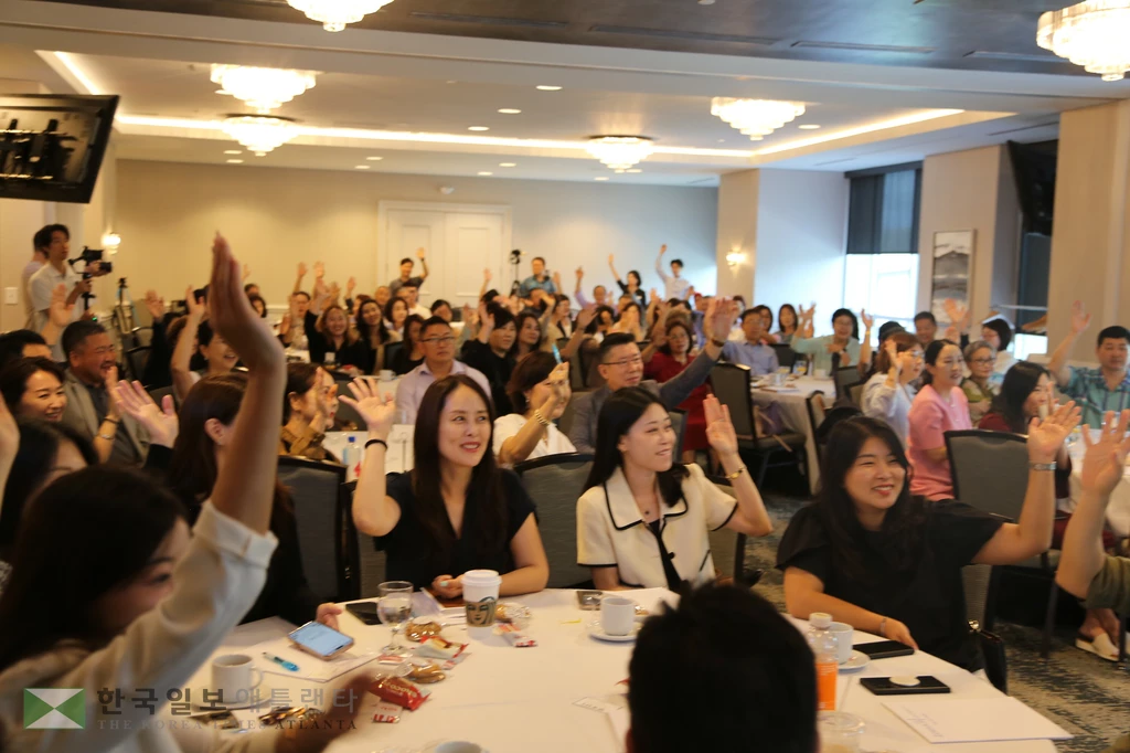 회원들이 거수로 차차기 회장 선거를 하고 있다.