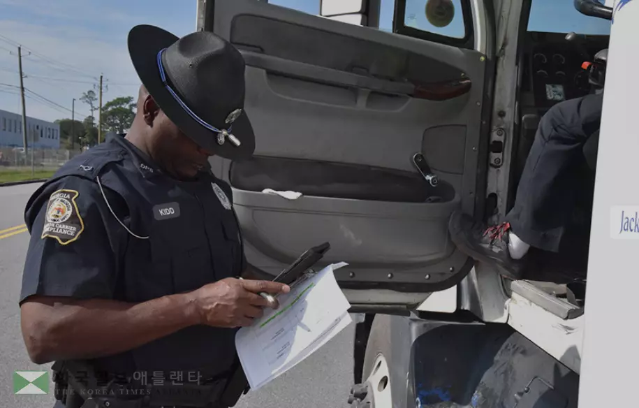 조지아 주순찰대원이 고속도로에서 대형트럭 검문을 하고 있다.주순찰대는 최근 공공안전국 명칭은 상업용 차량 단속국으로 변경하면서까지 대형트럭 단속을 강화하고 있다.<사진=올온조지아>