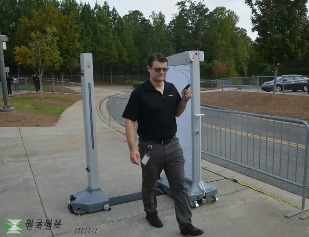 새학기부터 초등학교를 제외한 귀넷 모든 중고교에 설치 중인 금속탐지기를 운영사 직원이 작동 시범을 보이고 있다. <사진=귀넷 교육위원회>