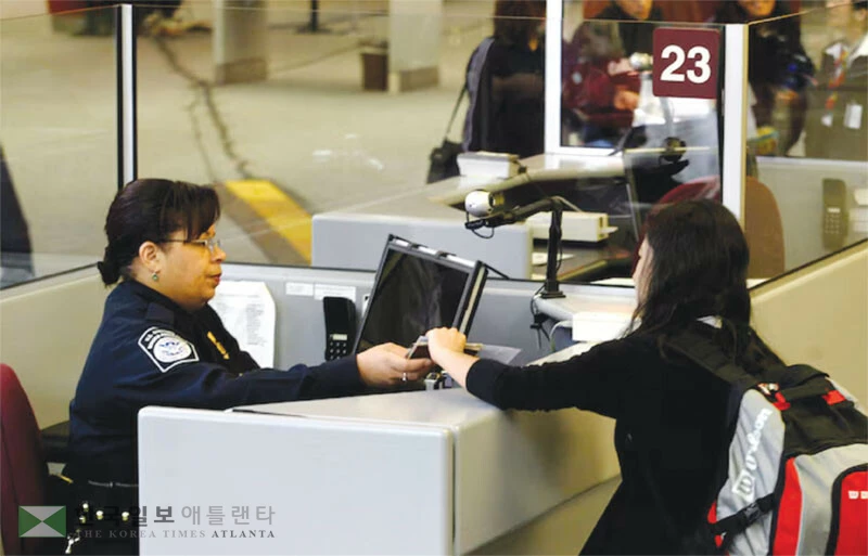  공항의 입국심사대에서 연방 세관국경보호국(CBP) 직원이 입국자 서류를 심사하고 있다. [로이터]