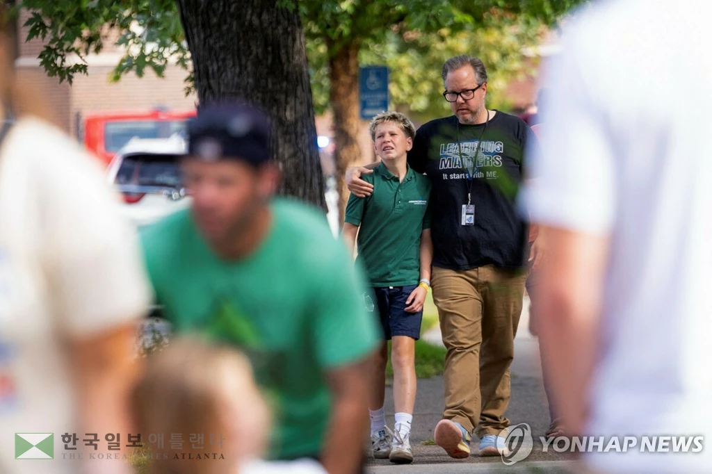 27일 총격 사건 벌어진 미니애폴리스 가톨릭학교에서 나오는 아이와 부모들[로이터=연합뉴스. 재판매 및 DB 금지]