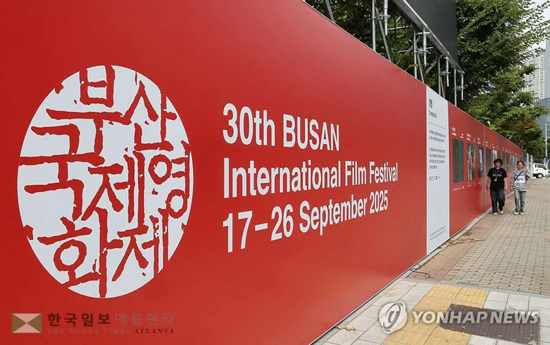  제30회 부산국제영화제(BIFF) 개막을 이틀 앞둔 15일(한국시간) 부산 해운대구 영화의전당 앞에 설치된 포스터 앞으로 시민이 지나가고 있다. [연합]