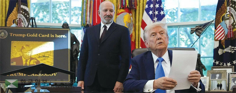  도널드 트럼프 대통령이 지난 19일 백악관 집무실에서 하워드 러트닉 상무장관과 함께 이른바 ‘골드카드’ 신청 사이트를 배경으로 비자 수수료 인상 행정명령을 공개하고 있다. [로이터]