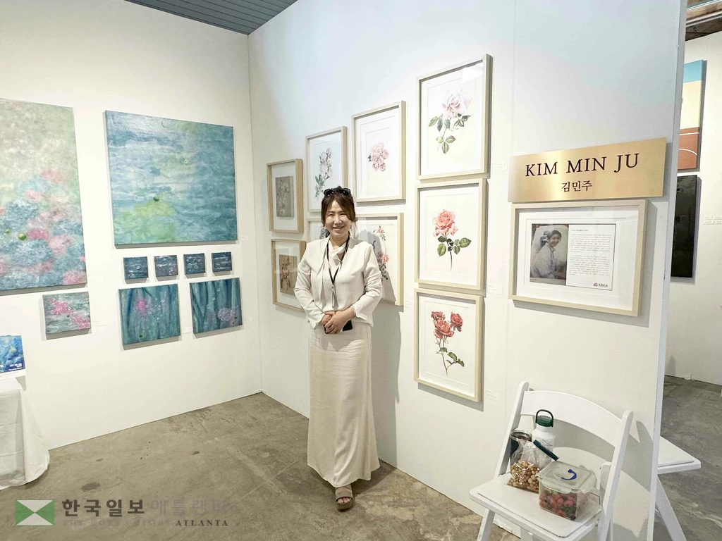 마리에타에 거주하는 김민주 동양화, 식물화 화가가 자신의 작품들과 함께 포즈를 취하고 있다.