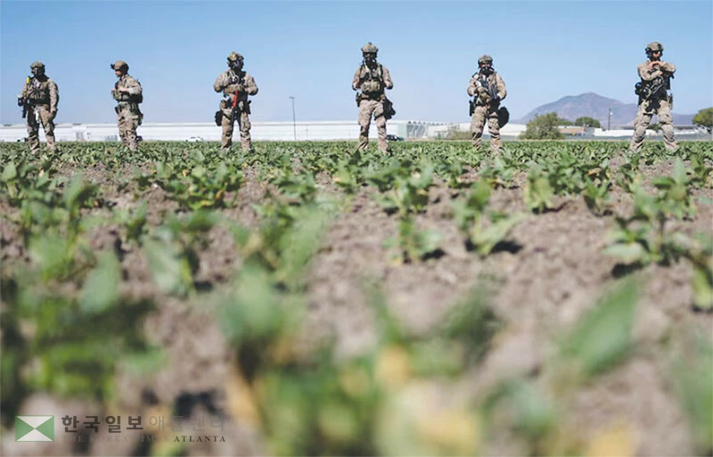  지난 7월 남가주 카마리요 지역 농장을 급습해 이민 단속을 벌인 중무장 요원들이 농장 한 가운데 배치돼 있다. [로이터]