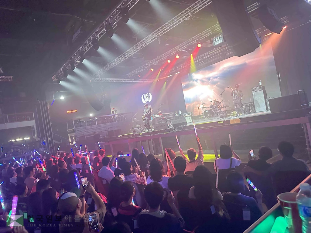 윤도현 밴드가 응원봉을 흔들며 떼창하는 관객과 하나가 되어 공연을 하고 있다.