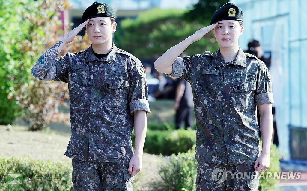 육군 현역 복무를 마친 그룹 BTS의 지민과 정국이 11일 오전 경기도 연천군 연천공설운동장에서 거수경례로 전역을 알리고 있다.(서울=연합뉴스)