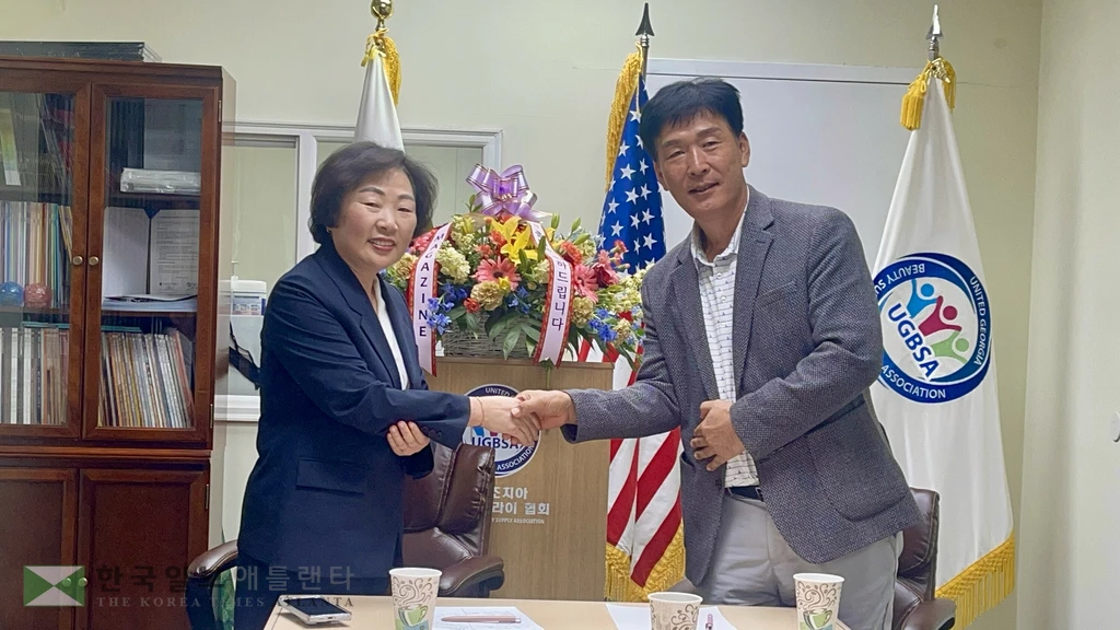 미미박 회장과 이강하 회장이 통합 발표 후 악수하고 있다.