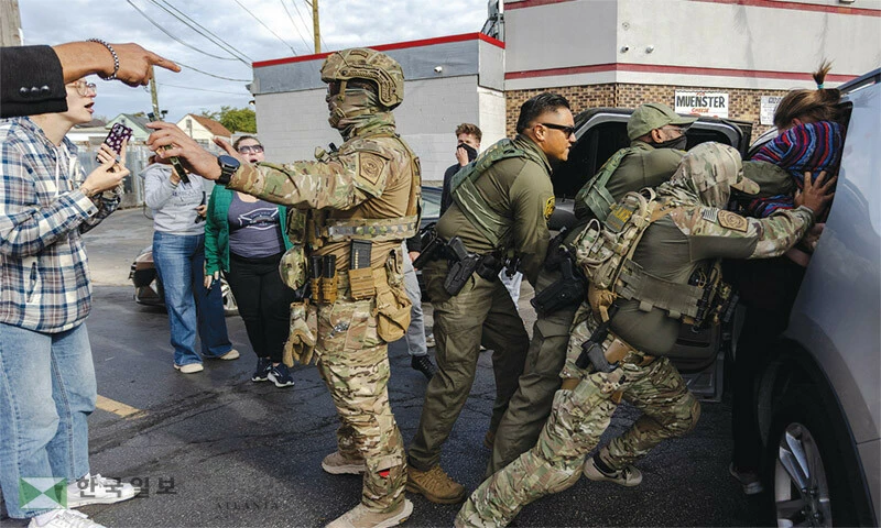  지난 25일 시카오에서 이민 단속 요원들이 한 남성을 강제 체포하고 있는 가운데 주민들이 이에 항의하고 있다. [로이터]