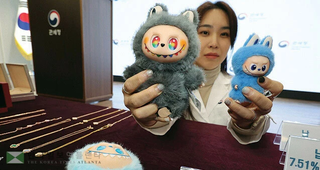  한국시간 5일 서울세관에서 관세청 관계자가 정품과 가소제가 검출된 ‘짝퉁’ 라부부 인형을 들어서 보여주고 있다. [연합]