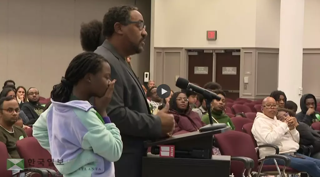 11일 열린 귀넷학군조정 공청회에서 한 학부모가 자녀와 함께 조정안에 대해 반대의견을 밝히고 있다.<사진=11얼라이브 뉴스 캡쳐>