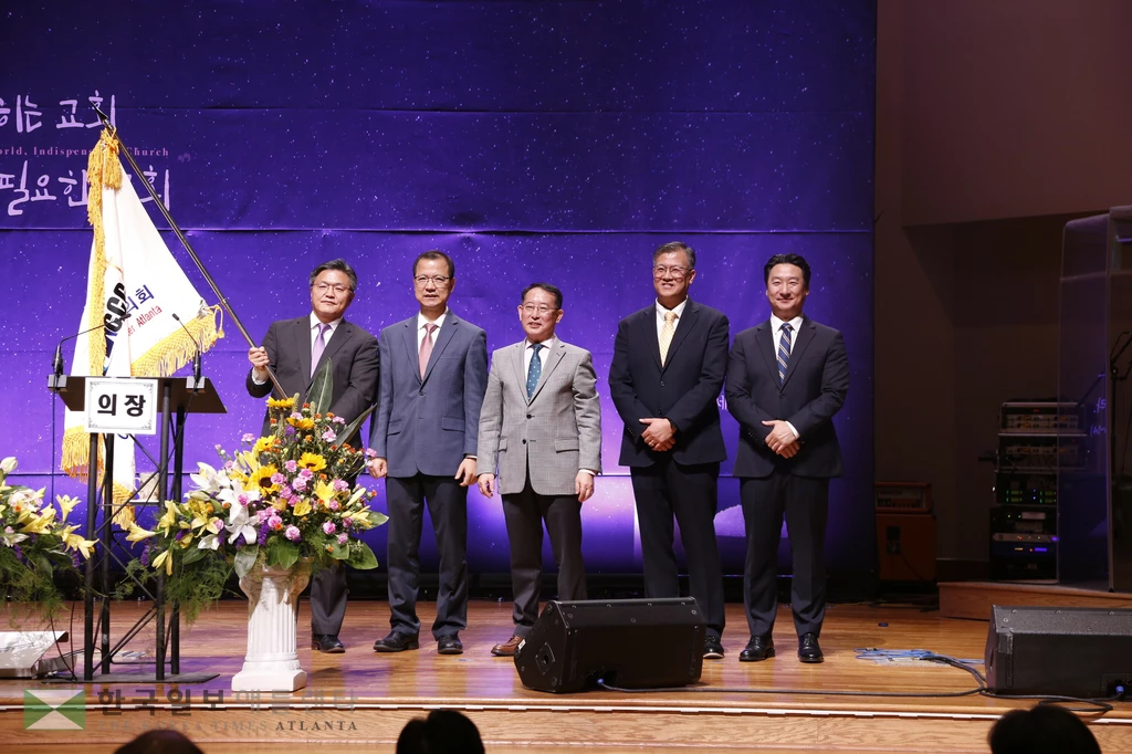 애틀랜타 한인교회협의회 회장으로 선출된 손정훈 목사가 협회기를 이양받고 흔들고 있다.