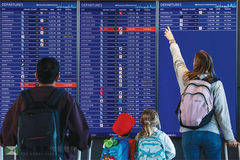 연방정부 셧다운이 공식 종료된 13일 워싱턴 DC의 덜레스 국제공항에서 한 가족이 항공기 운항 스케줄을 확인하고 있다. [로이터]