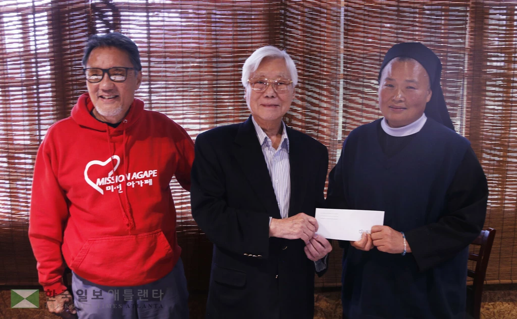 조중식 회장이 조지아 꽃동네 김나지오 수녀에게 성금을 전달하고 있다.