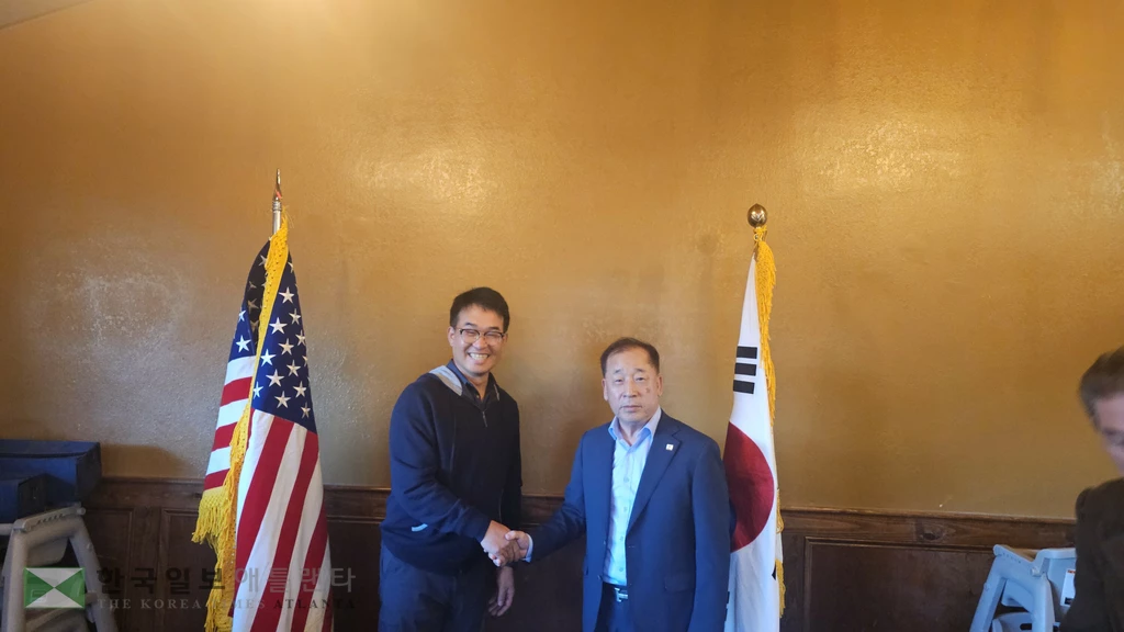 북부플로리다한인회 현직 조경구 회장(오른쪽)이 조남용 신임 회장과 악수하고 있다.