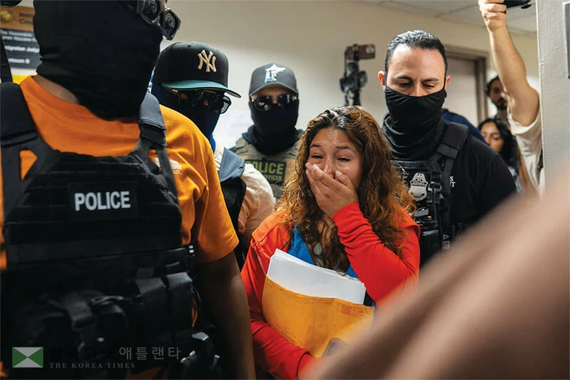  뉴욕 이민법원에서 복면을 한 연방 이민단속 요원들이 법정 출두를 앞둔 이민자 여성을 체포하고 있다. [로이터]