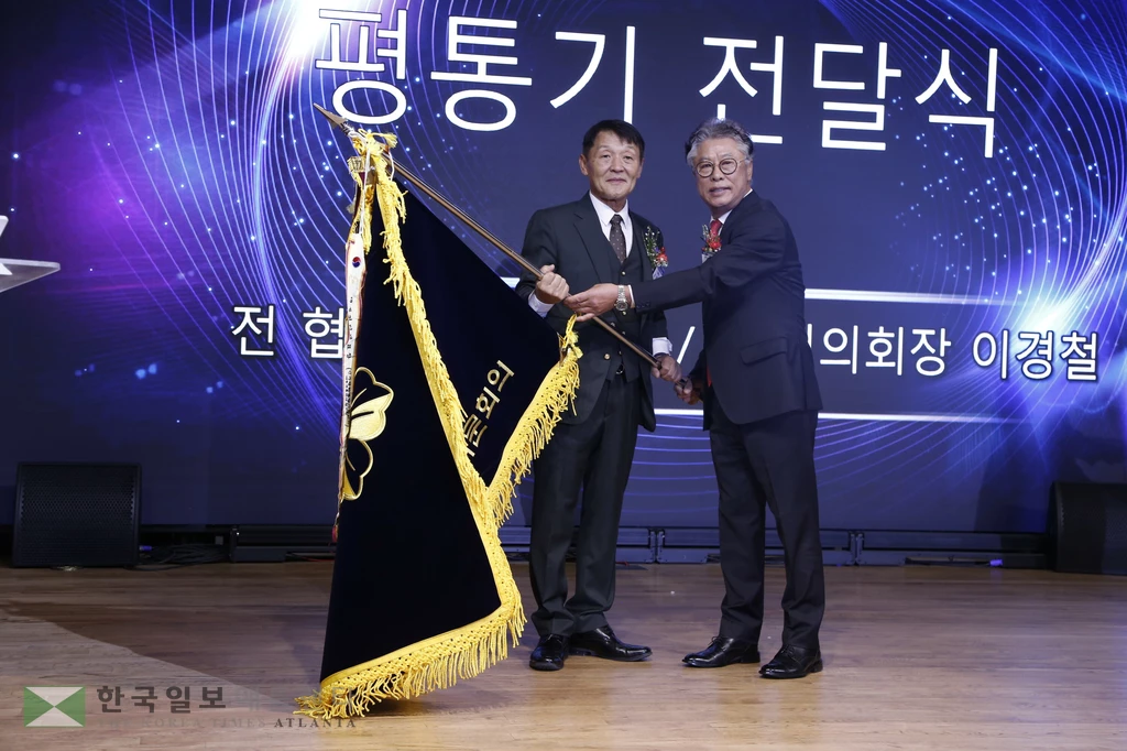 21기 오영록 회장이 22기 이경철 회장에게 민주평통기를 인양하고 있다.