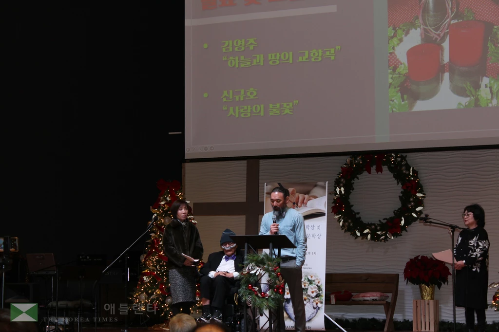 우수상을 수상한 신규호 씨의 시 ‘사랑의불꽃(Eternal Flame of Love)’을 아들이 대신 낭독하고 있다.