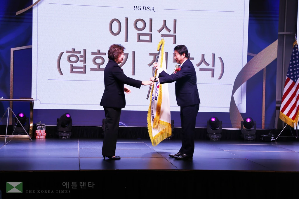 미주조지아뷰티협회 미미박 회장이 이종흔 신임회장에게 협회기를 이양하고 있다. 이 회장은 내년부터 통합 조지아뷰티협회 회장으로 활동하게 됐다.