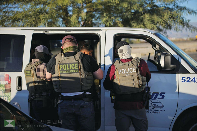  지난 19일 복면을 한 이민 단속 요원들이 팜스프링스 인근 메카 지역에서 이민 단속을 펼쳐 체포된 이민자를 차량에 태우고 있다. [로이터]
