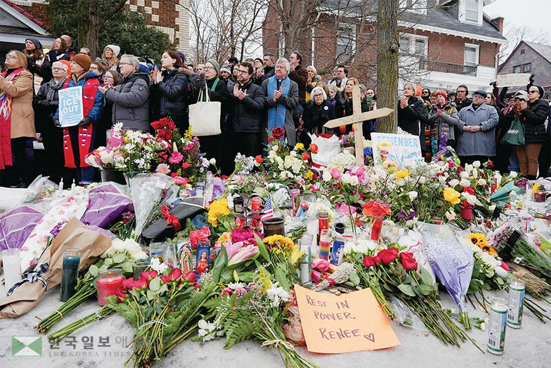  지난 7일 르네 니콜 굿이 사망한 사건 현장에 8일 수많은 꽃과 촛불들이 놓여진 가운데 주민들이 모여 사망자를 추모하고 있다. [로이터]