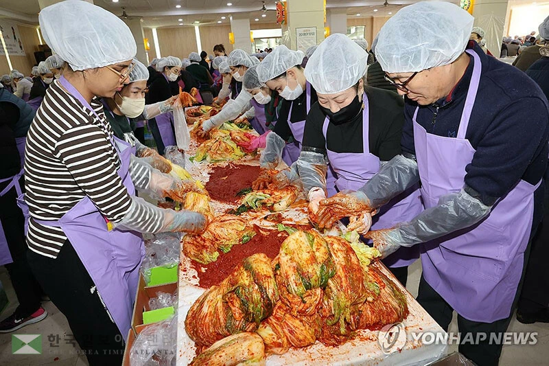  10일(한국시간) 부산 부산진구 삼광사 식당에서 열린 ‘제8회 천태종 삼광사와 천태종복지재단 부산지부가 함께하는 김장나눔문화제’에서 결혼이주여성, 불자 등 400여 명이 절임배추를 양념에 버무리고 있다. 이날 담근 김장김치 1만 포기를 지역의 홀몸 어르신 등 소외계층 1500가구에 전달할 예정이다. 2025.12.10 [연합뉴스]