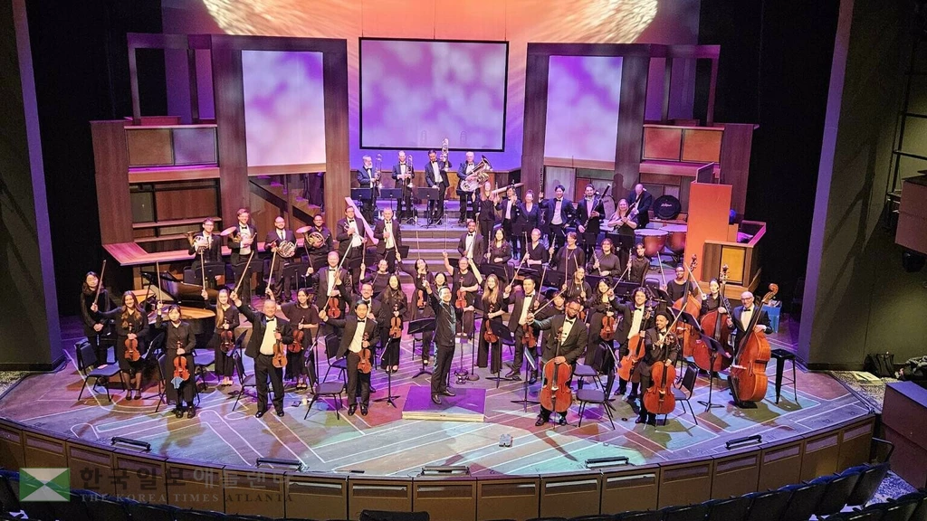 지난 11일 오로라 극장에서 열린 로렌스빌 심포니 오케스트라 공연 직후, 박평강 지휘자(가운데)와 단원들이 관객들의 환호에 답하고 있다.